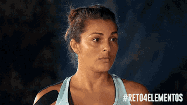 a woman wearing a blue tank top with #reto4elementos on the bottom