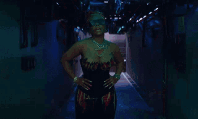 a woman wearing sunglasses is standing in a dark room