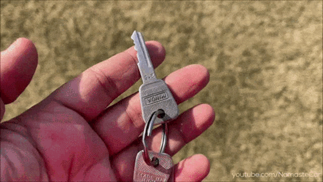 a person is holding a key that says ' yomii ' on it