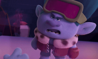a troll wearing goggles and a scarf is standing on a purple surface .