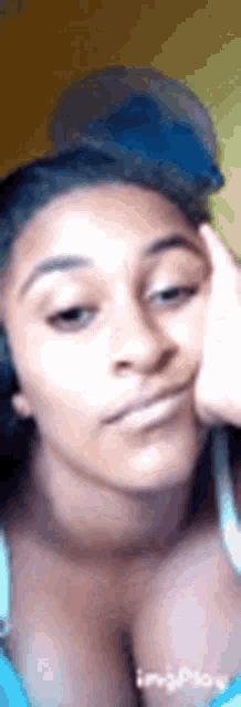 a woman is making a funny face with her hand on her forehead .