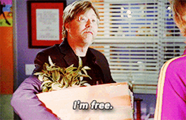 a man in a suit holding a plant says i 'm free