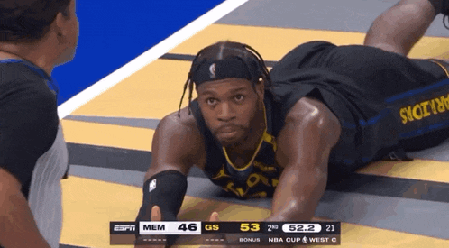 a basketball player is laying on the floor during a game against the warriors