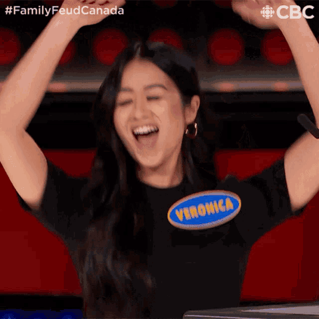 a woman with her arms in the air wearing a veronica t-shirt