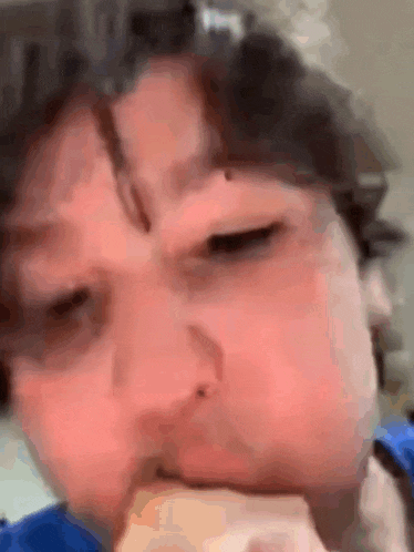 a close up of a person eating a piece of food with their mouth .