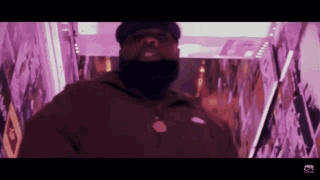 a man with a beard and a hat is standing in a purple room .