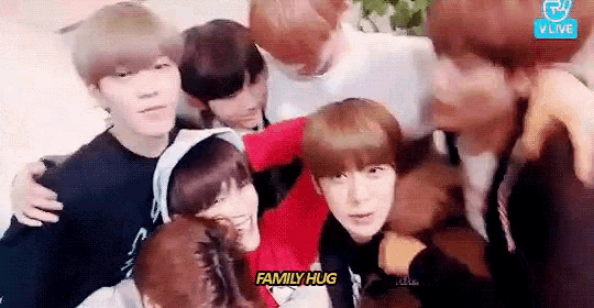 a group of young people are hugging each other and smiling .