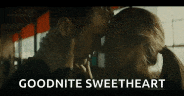 a man and a woman are kissing with the words `` goodnite sweetheart '' written on the bottom .
