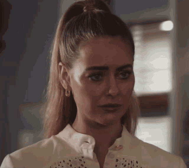 a woman with a ponytail is wearing a white shirt