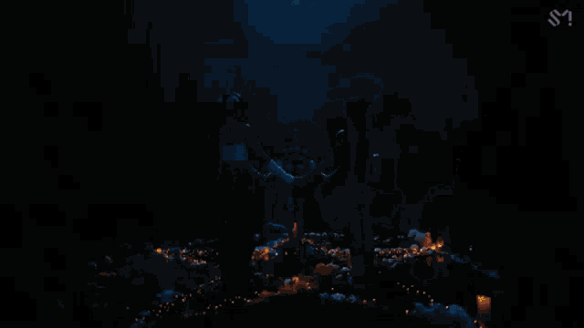 three women are standing next to each other in a dark room and looking at something .