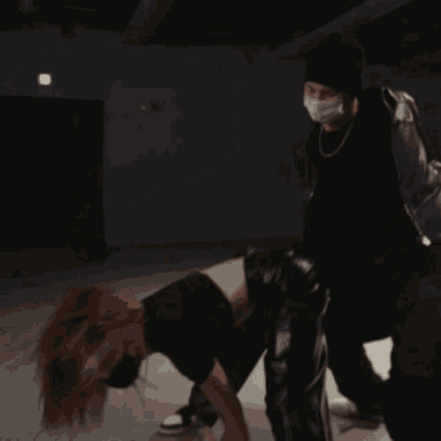 a man wearing a face mask stands next to a woman