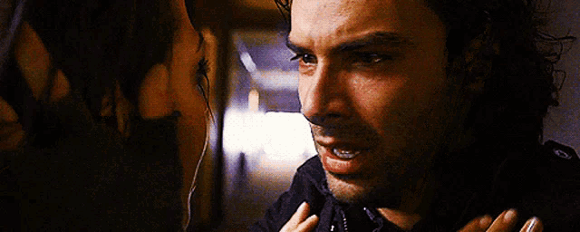 a man and a woman are looking at each other .