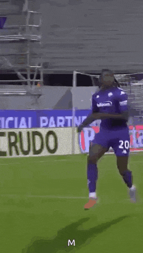 a soccer player in a purple shirt and shorts is running on a soccer field .