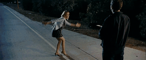 a man and a woman are standing on the side of a road