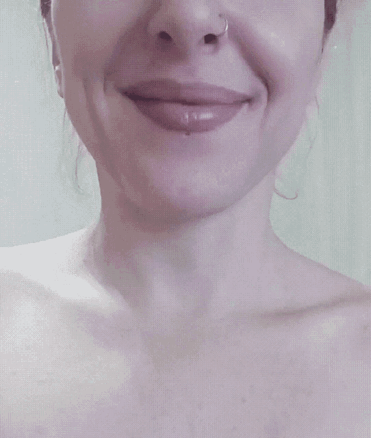 a close up of a woman 's face with a ring in her nose
