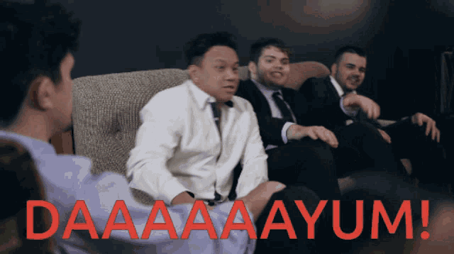 a group of men are sitting on a couch with the words daaaaayum written in red