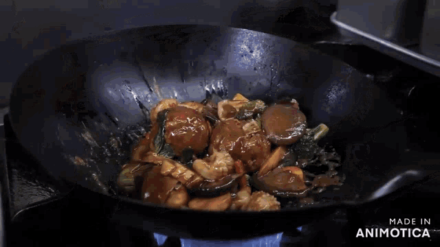 a pan of food is being stirred with a spatula and the words made in animotica are visible in the corner