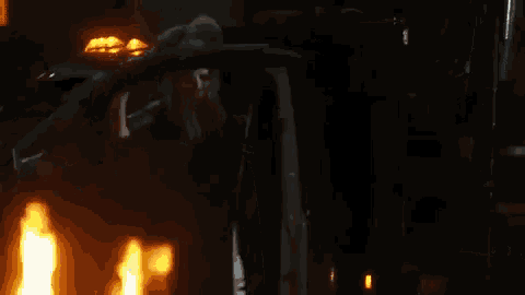 a man is standing in front of a burning car .