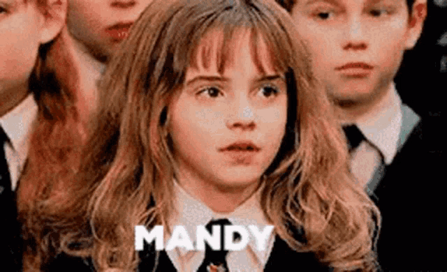 a young girl in a school uniform is standing in front of a group of children and says mandy .
