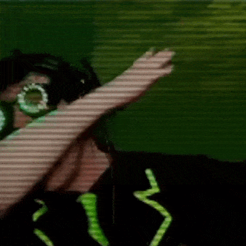 a person wearing headphones and glasses is doing a dab with their hand .