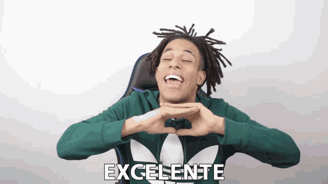 a man in a green adidas shirt is making a heart with his hands