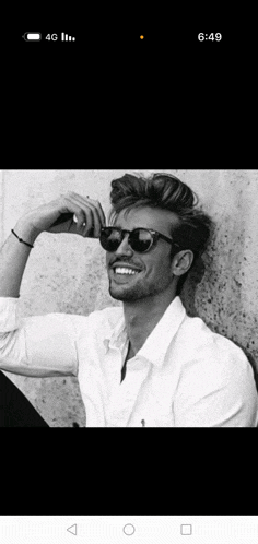 a black and white photo of a smiling man wearing sunglasses