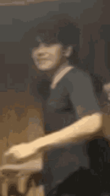 a blurry picture of a man in a black shirt dancing in a room .