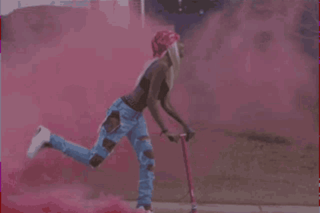 a woman is standing on one leg while holding a scooter