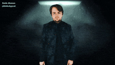 a man with a beard is standing in front of a blue background