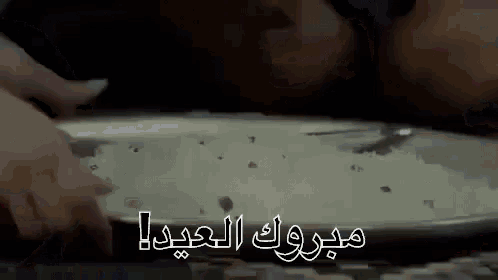 a close up of a person 's hands on a table with the words `` congratulations '' written in arabic .
