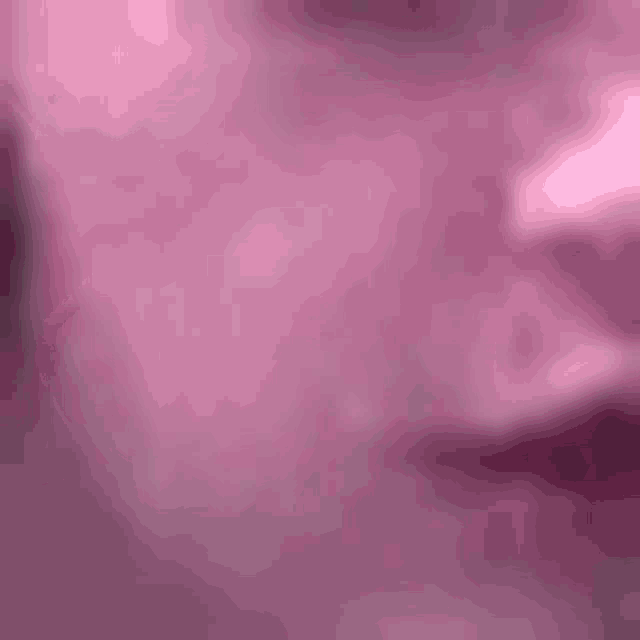a blurry picture of a pink and green background with a purple object in the foreground and a green object in the background .