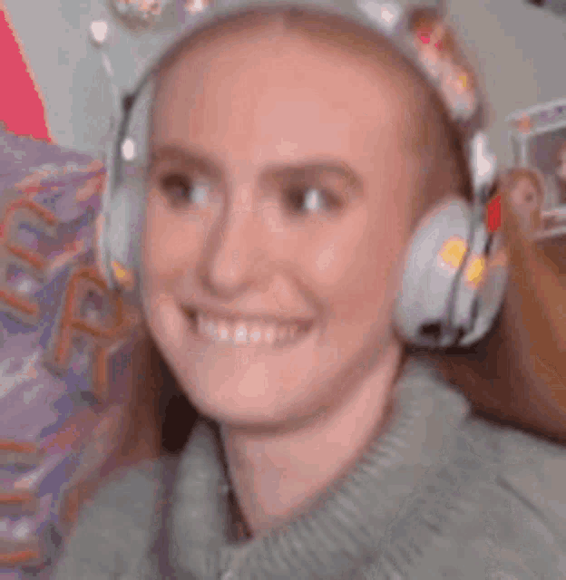 a woman is wearing headphones and smiling .
