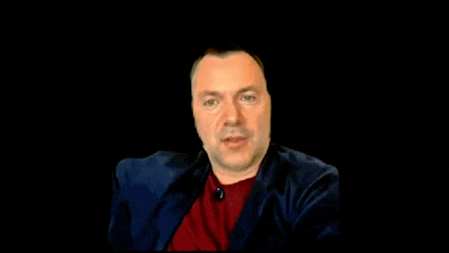a man in a suit is making a fist in the air .