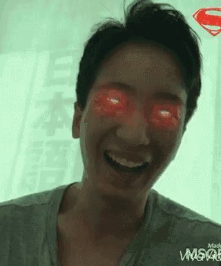 a man with red eyes is smiling and looking at the camera with a superman logo in the background .