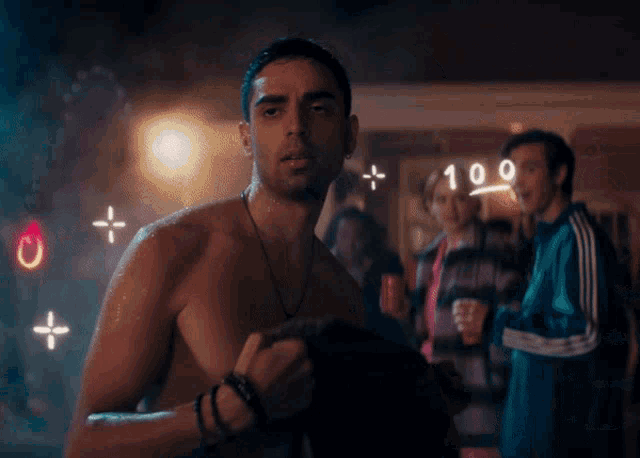 a shirtless man is standing in front of a 100 sign