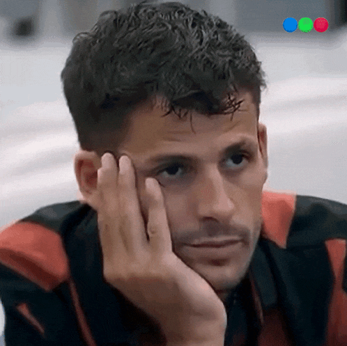 a man rests his head on his hand and looks at something