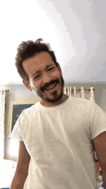 a man with a beard is wearing a white shirt