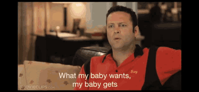 a man sitting on a couch with the words what my baby wants my baby gets