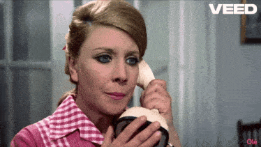 a woman is talking on a phone with the word veed on the bottom right