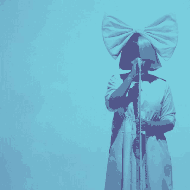 a woman singing into a microphone with the words #spain needs sia above her