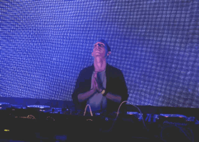 a man with his hands folded in front of a screen that says pioneer
