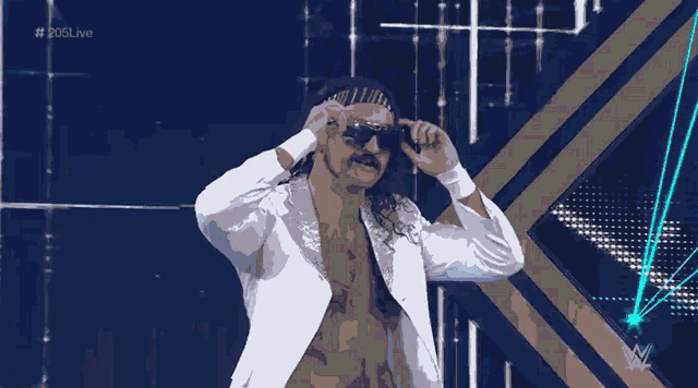 a man wearing a white jacket and a headband with the hashtag # 205live on the bottom right