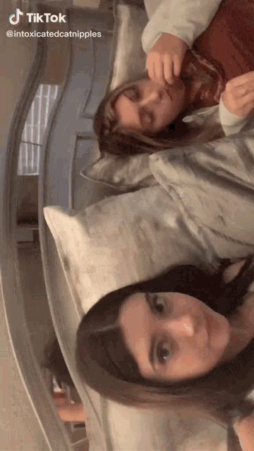two girls laying on a bed with a tiktok watermark on the bottom right