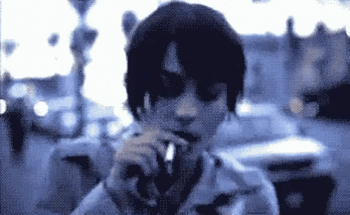 a woman is smoking a cigarette in a blurry photo
