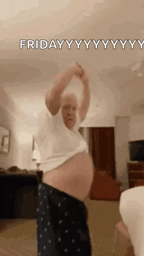 a man is dancing in a living room with his shirt off and his belly visible .