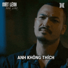 a man with a beard says anh không thích in a dark room