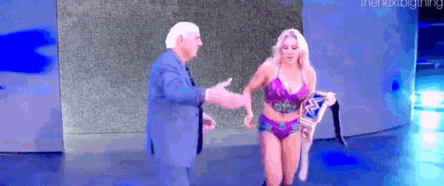 a man and a woman are shaking hands on a stage .