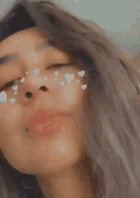 a close up of a woman 's face with hearts on her nose .
