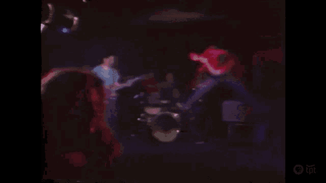a blurry picture of a band playing instruments on stage