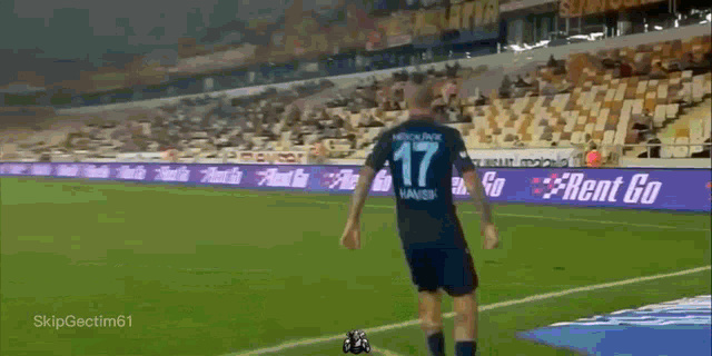 a soccer player with the number 17 on his jersey stands on the field